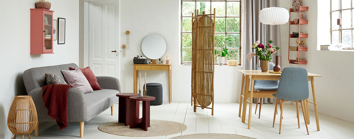 Salon/séjour avec vitrine rose, canapé convertible gris, paravent en bambou, bureau en bambou et chaises grises
