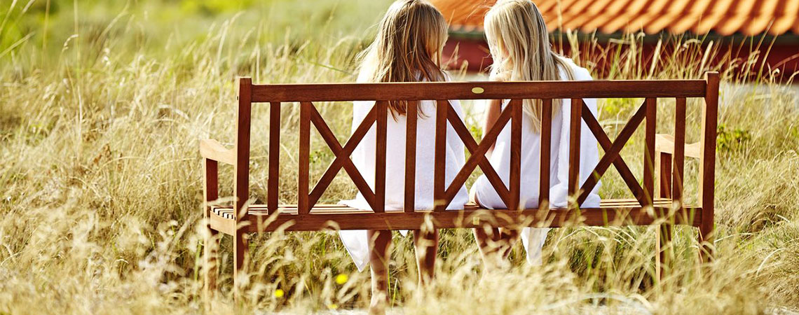 Deux femmes sur un banc en bois en campagne