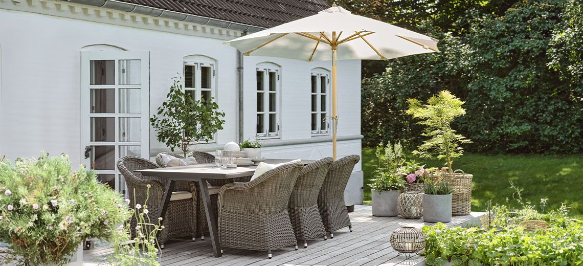 Parasol sur une terrasse dans un jardin avec table de jardin et chaises de jardin