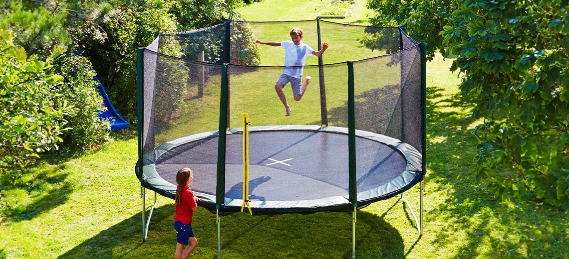 Enfants jouant sur un grand trampoline dans le jardin 