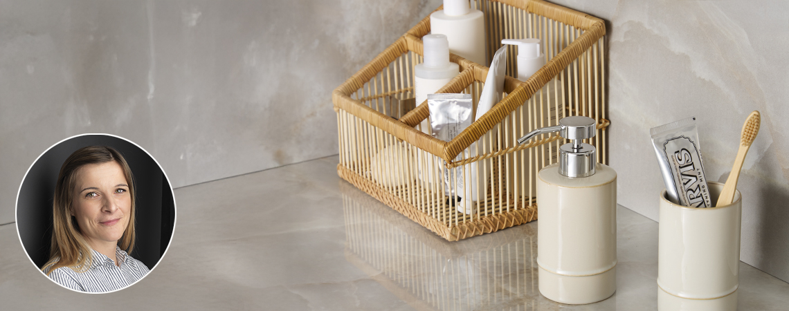 Organisateur de maquillage en bambou, distributeur de savon et porte-brosses à dents dans une salle de bain. Photo de Kathrine Møller Vinther