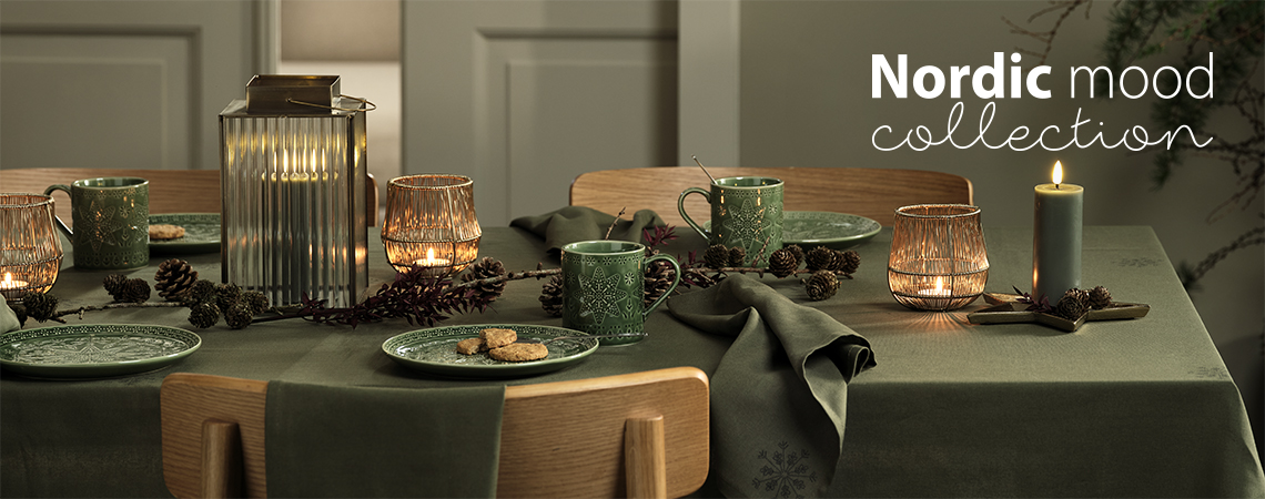 Table de Noël avec des assiettes vertes, des mugs verts, une lanterne, des bougies 