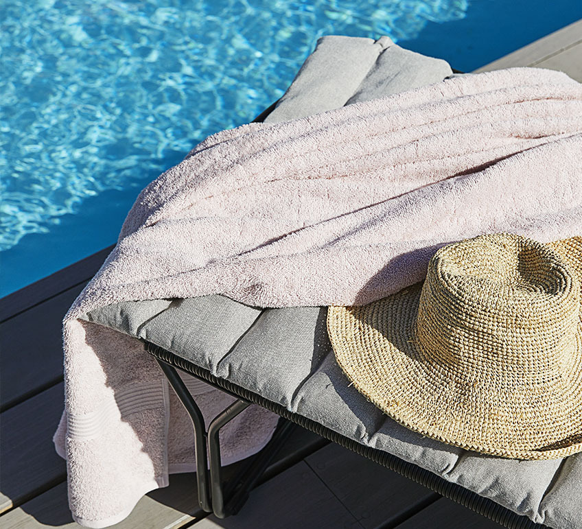 Chaise longue avec un coussin au bord de la piscine