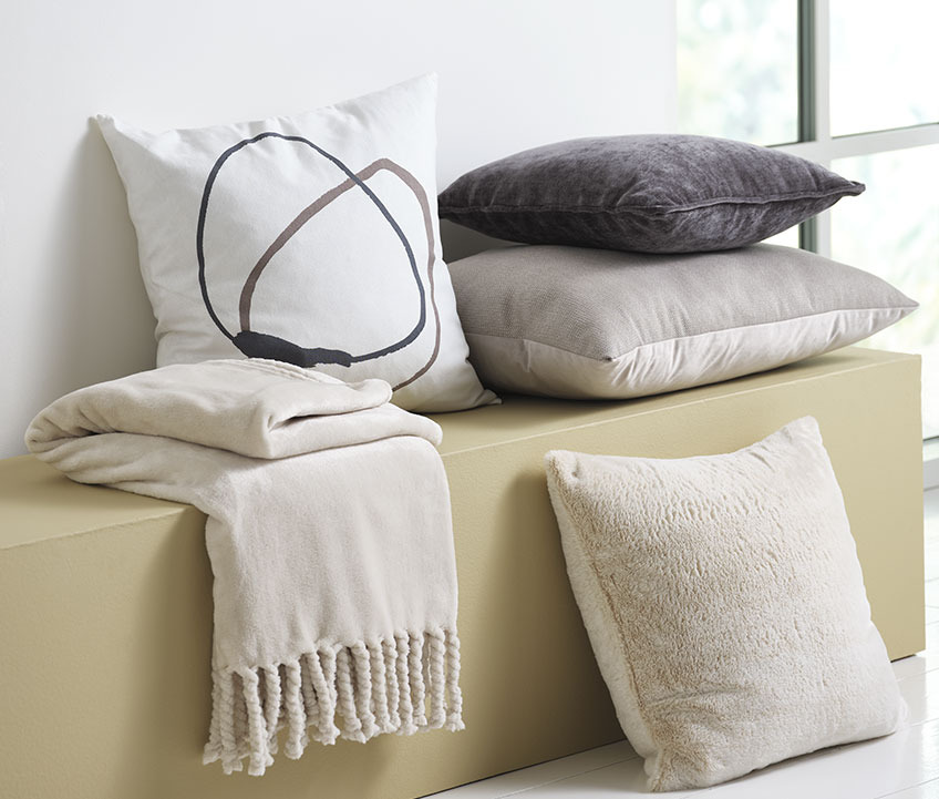 Housse de coussin POPPEL blanche avec motif Housse de coussin blanche à motif graphique et plaid polaire sur un banc