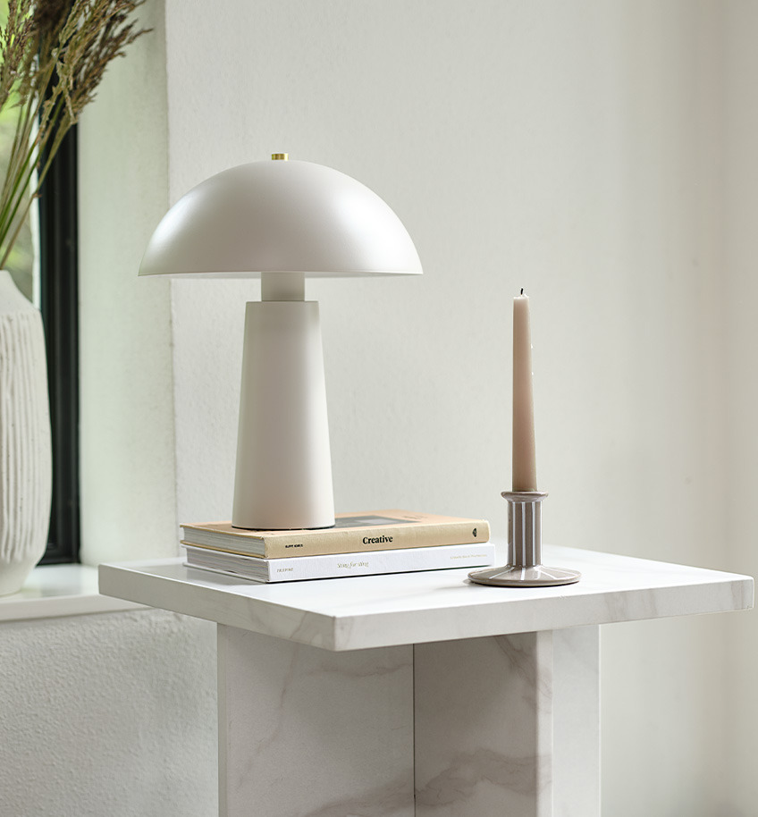 Lampe de table classique en beige clair avec détail en laiton sur une table d'appoint en aspect marbre