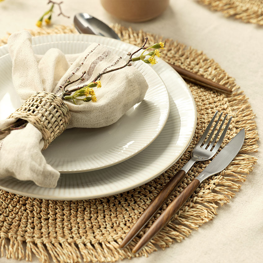 Articles de table : assiette blanche cannelée, serviette tissu, rond de serviette, ménagère de couverts et set de table