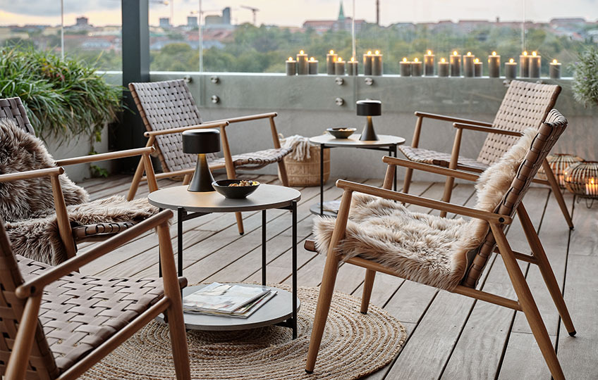 Petite table d’appoint avec plateau en fibre-ciment et fauteuils lounges sur un patio
