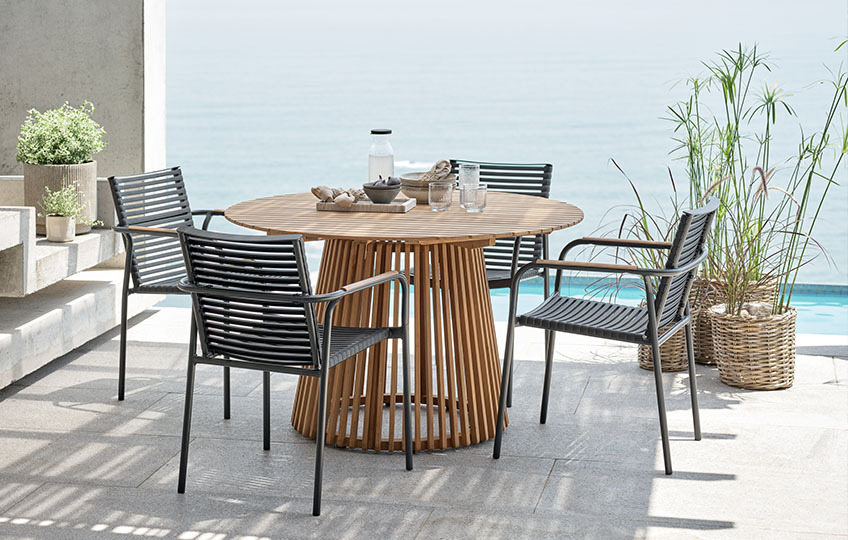 Mobilier de jardin comprenant une table de jardin en teck et des chaises de jardin en plastique