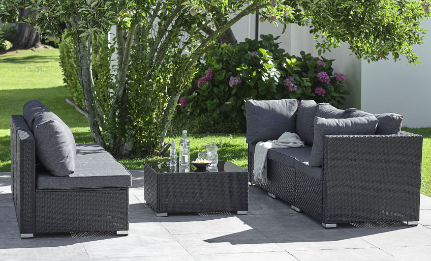 Mobilier de jardin modulable noir configuré en deux canapés face à face, séparés par une table lounge