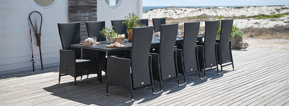 Grande table de jardin et chaises de jardin pour 10 à 12 personnes sur une terrasse à la plage