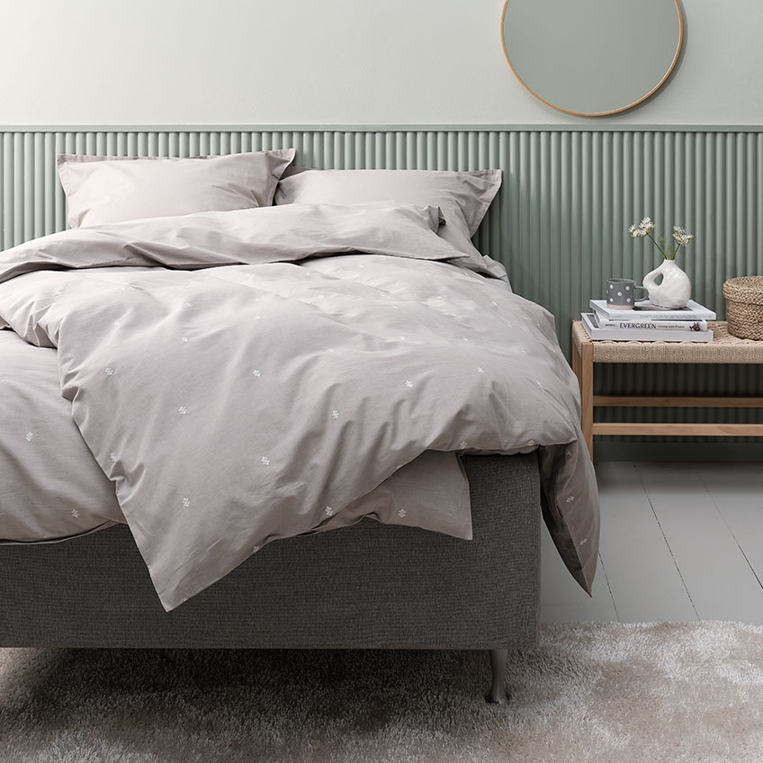 Parure de lit gris clair et literie en coton avec taie d’oreiller sur un lit dans une chambre