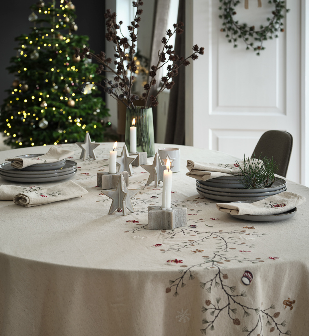 Table de Noël joliment décorée avec nappe de Noël brodée 