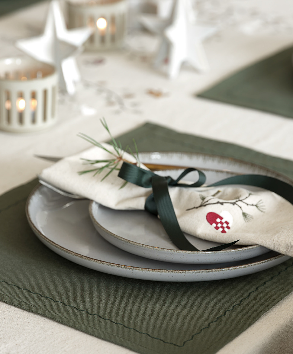 Serviette de Noël bien pliée sur une assiette et un set de table