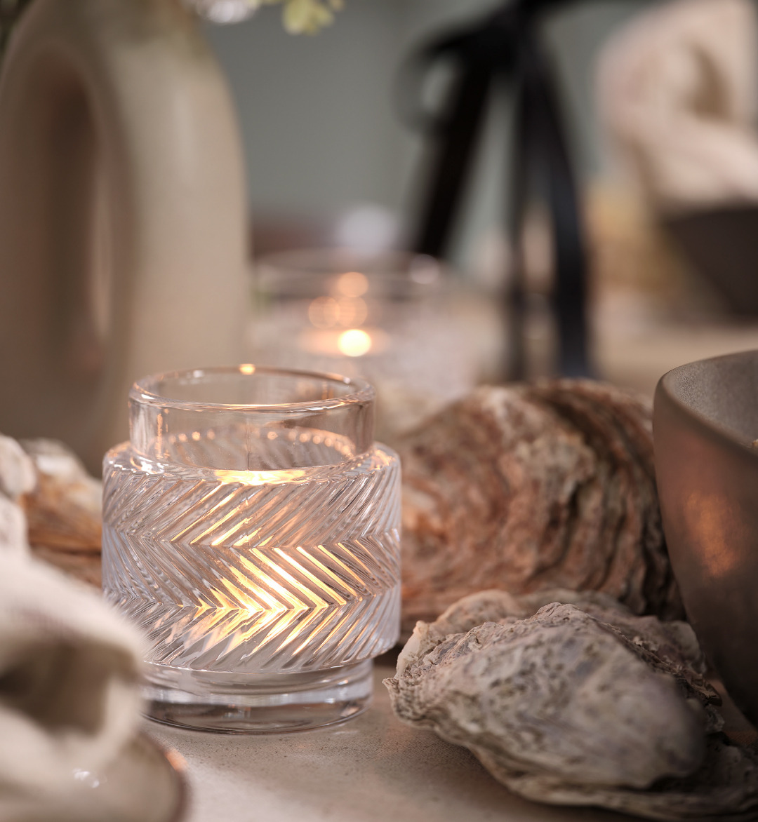 Photophore en verre au milieu d'une décoration de table