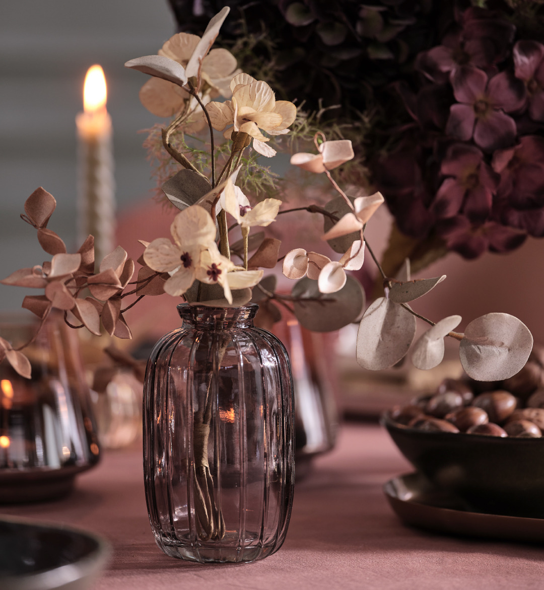 Vase en verre gris avec fleurs artificielles sur une table