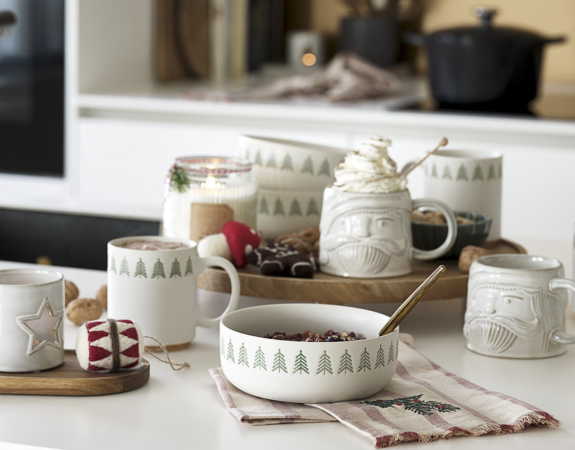 Tasses de Noël, bols et bougies sur une table