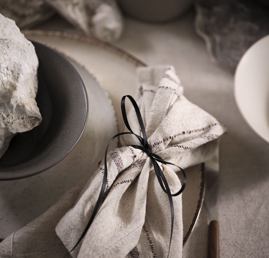 Mise en place avec des assiettes, un bol et une serviette en tissu