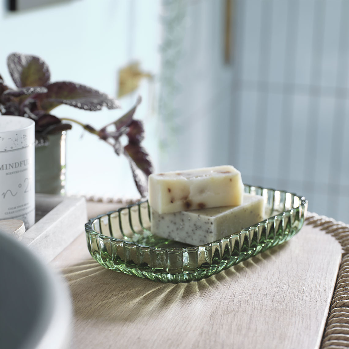 Plateau rectangulaire en verre transparent vert avec du savon sur un lavabo de salle de bain