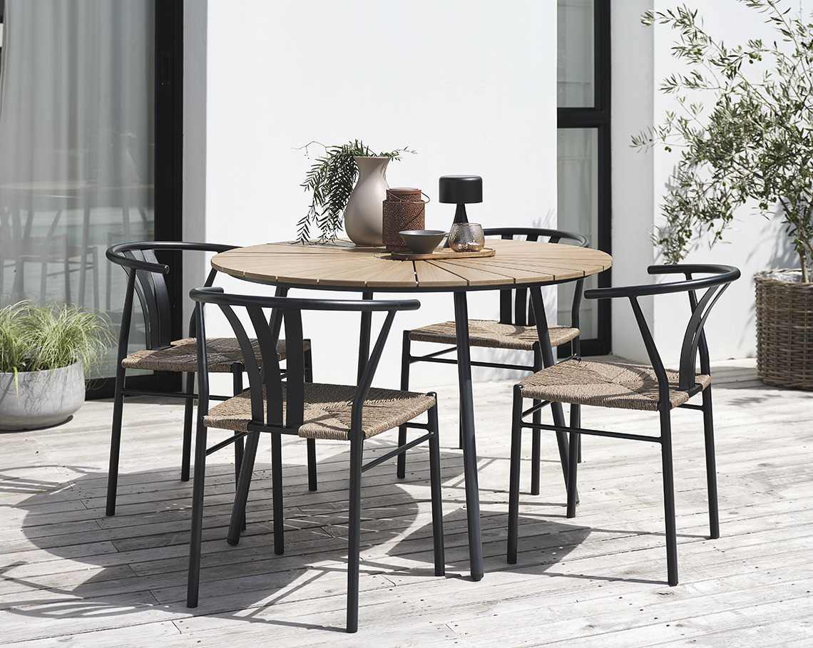 Table de jardin RANGSTRUP avec un diamètre de 130cm et chaises de jardin TAGMARK Une table de jardin ronde avec 4 chaises sur un patio