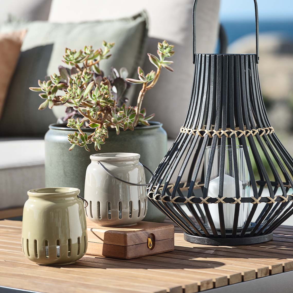 FISKEHEJRE and SIVHAUK lanterns Outdoor lanterns in different materials and sizes on outdoor lounge table