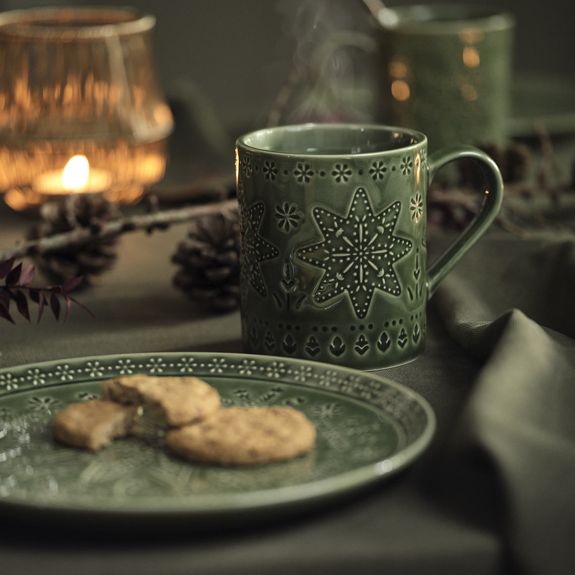 Une assiette de Noël verte et un mug sur une table 