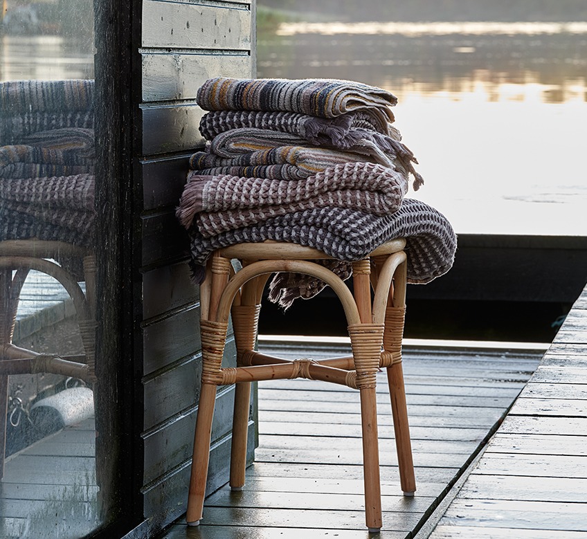 Hand towels, guest towels and striped towels on a stool by a lake