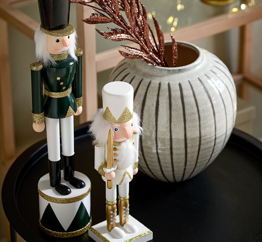 Deux figurines de Noël et vase sur table basse noire