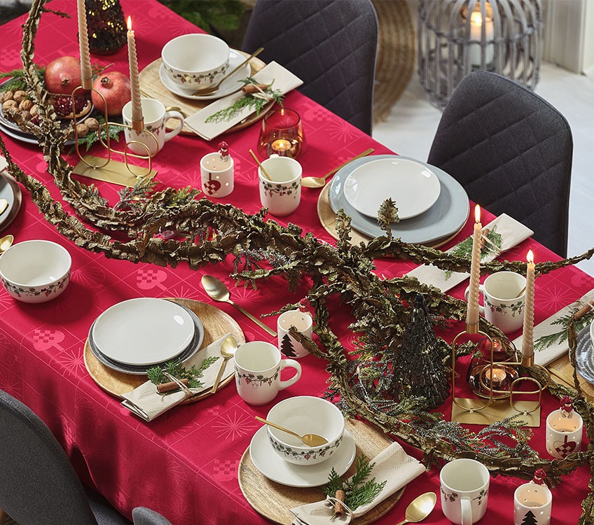 Table de Noël avec une nappe rouge et vaisselle dorée