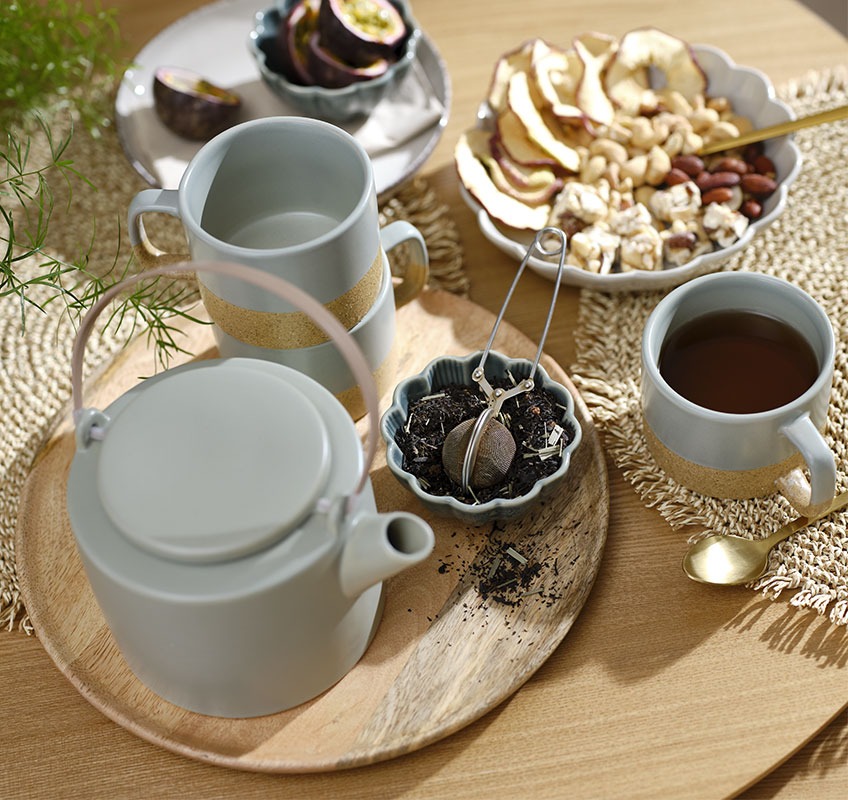 Plateau en bois avec une théière, des mugs et petits bols à biscuits