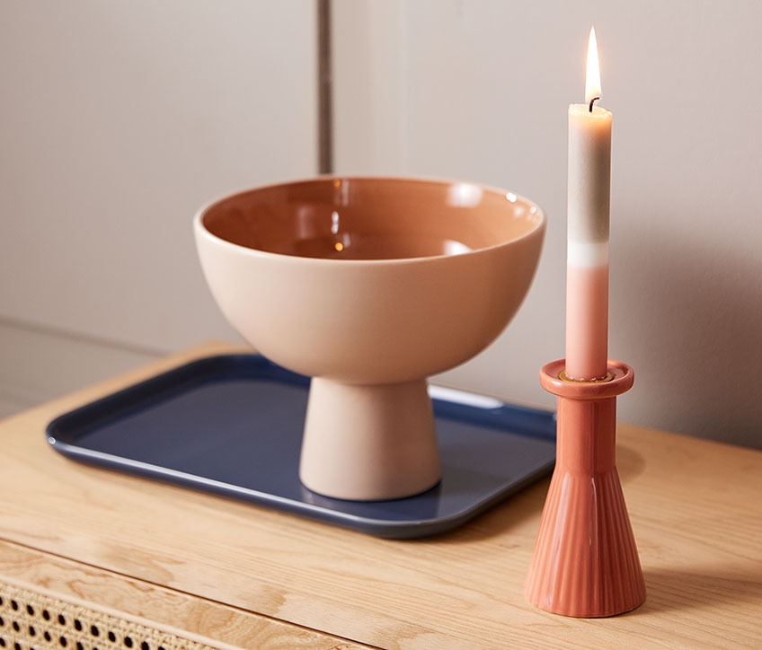 Chandelier THRISTAN avec la bougie IGNI, le plateau LEIV et le bol CHRIS Bol sur un plateau, à côté d’une bougie et d’un chandelier à rayures