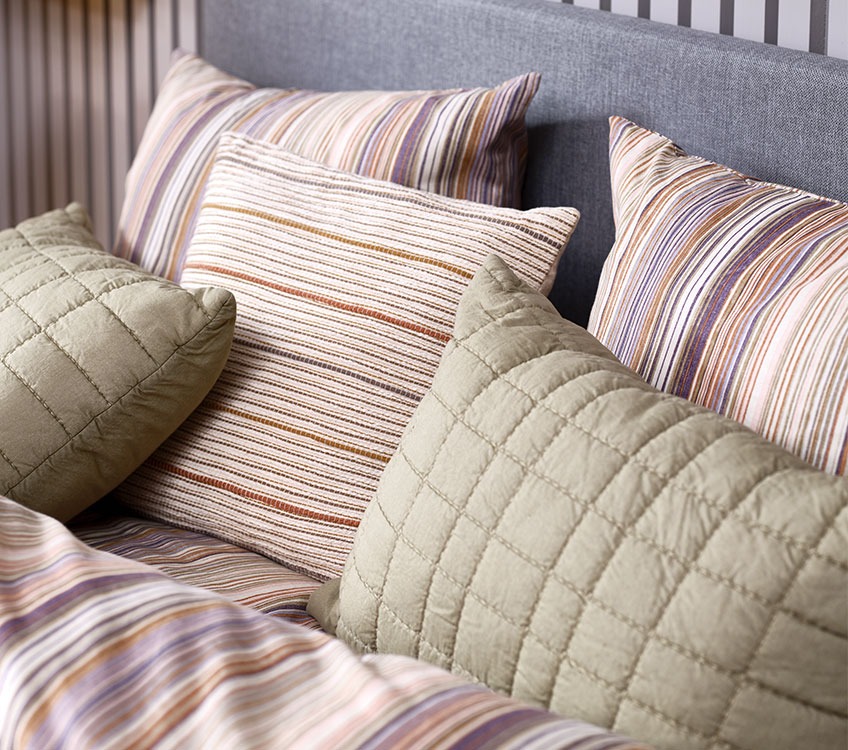 Parure de lit rayée avec des coussins décoratifs et des coussins verts