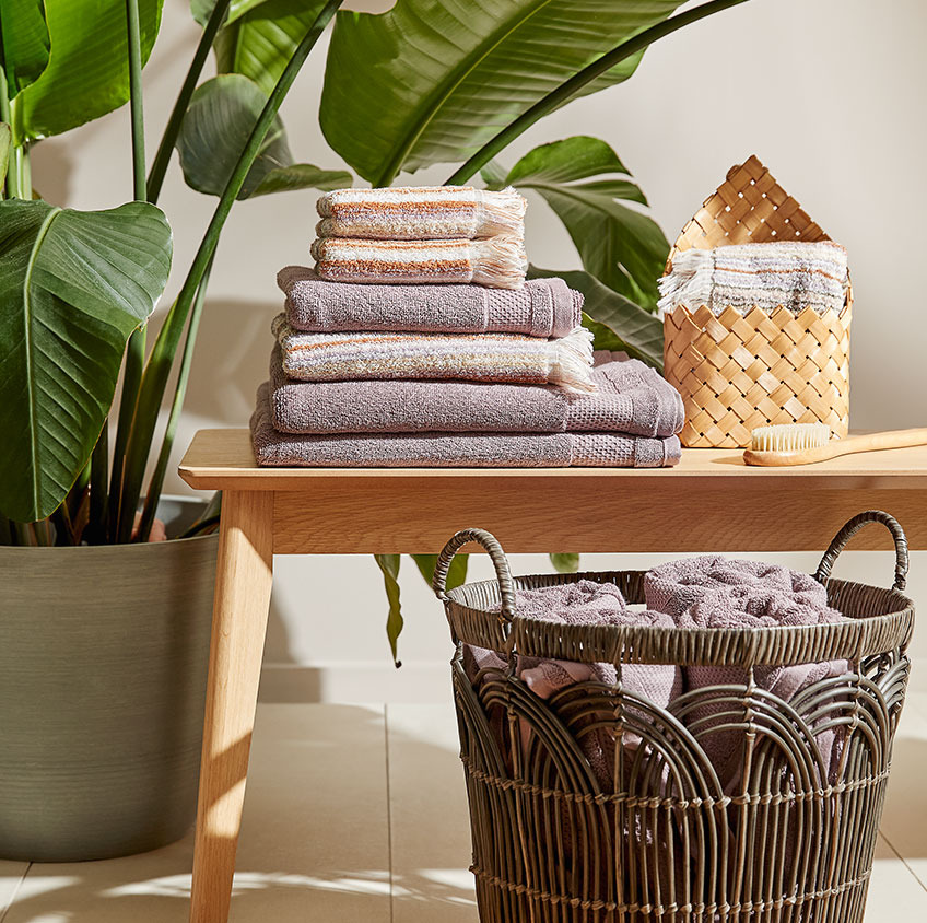 Serviettes en coton et panier dans une salle de bain