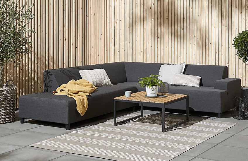 Ensemble lounge avec la table GAMST et le canapé UHRE. Canapé lounge avec une table de jardin en bois