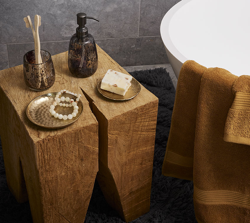 Petit support en bois, avec un gobelet à brosse à dents, un distributeur à savon dans une salle de bain