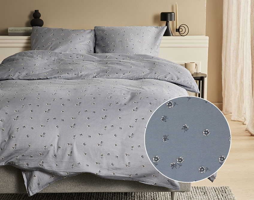Bed with sateen bedding with little flowers on a dark grey background 