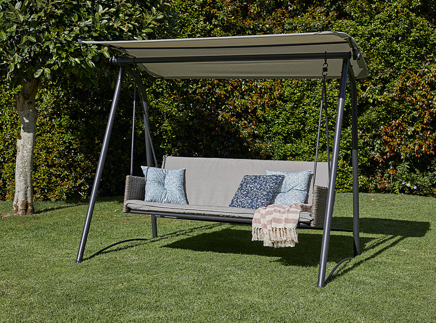 JUELSMINDE hanging sofa Grey hanging sofa in garden with cushions and throw