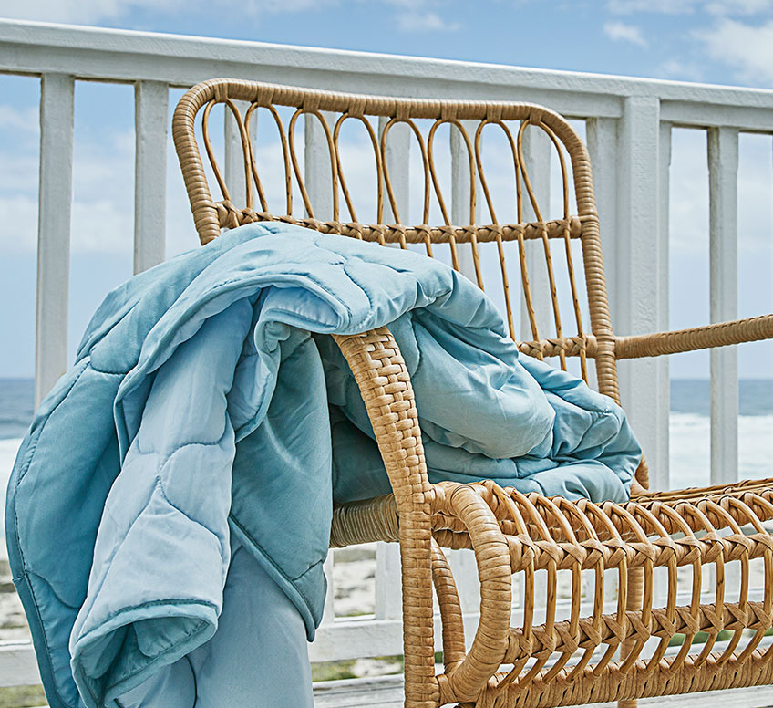 Fauteuil lounge avec couette d’été sur un balcon 